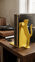 Yellow cat silhouette vinyl record bookend on a wooden shelf.