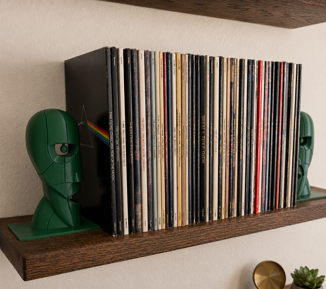 Dark green Division Bell inspired 3D printed vinyl record bookends on a wooden shelf.