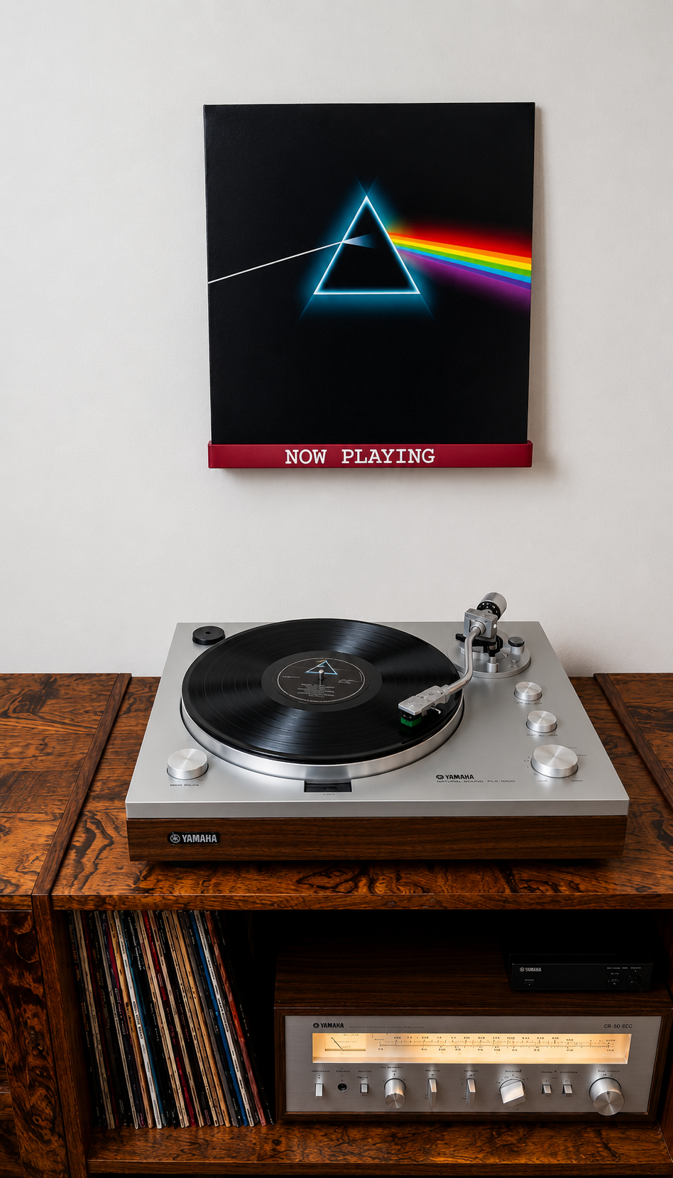 Dark red wall-mounted vinyl record shelf with white 'NOW PLAYING' text.