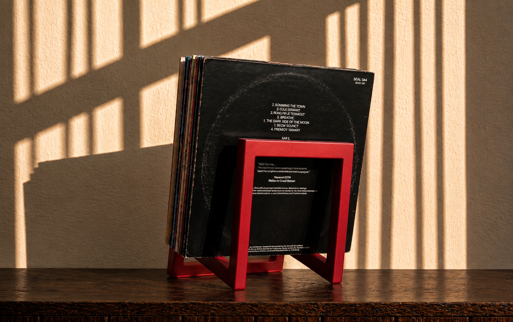 Rear view of a red square-frame vinyl record stand holding albums.