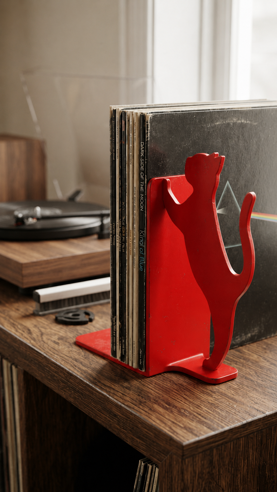 Red cat silhouette vinyl record bookend on a wooden surface.