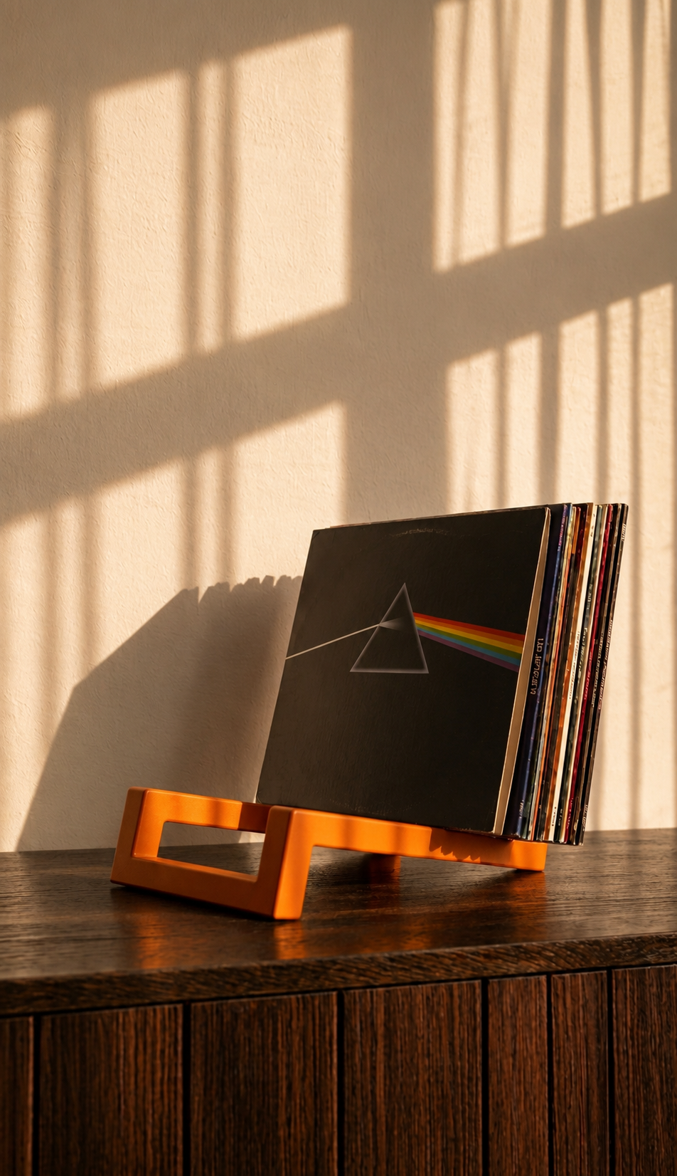 Orange geometric vinyl record holder displaying a collection of albums.