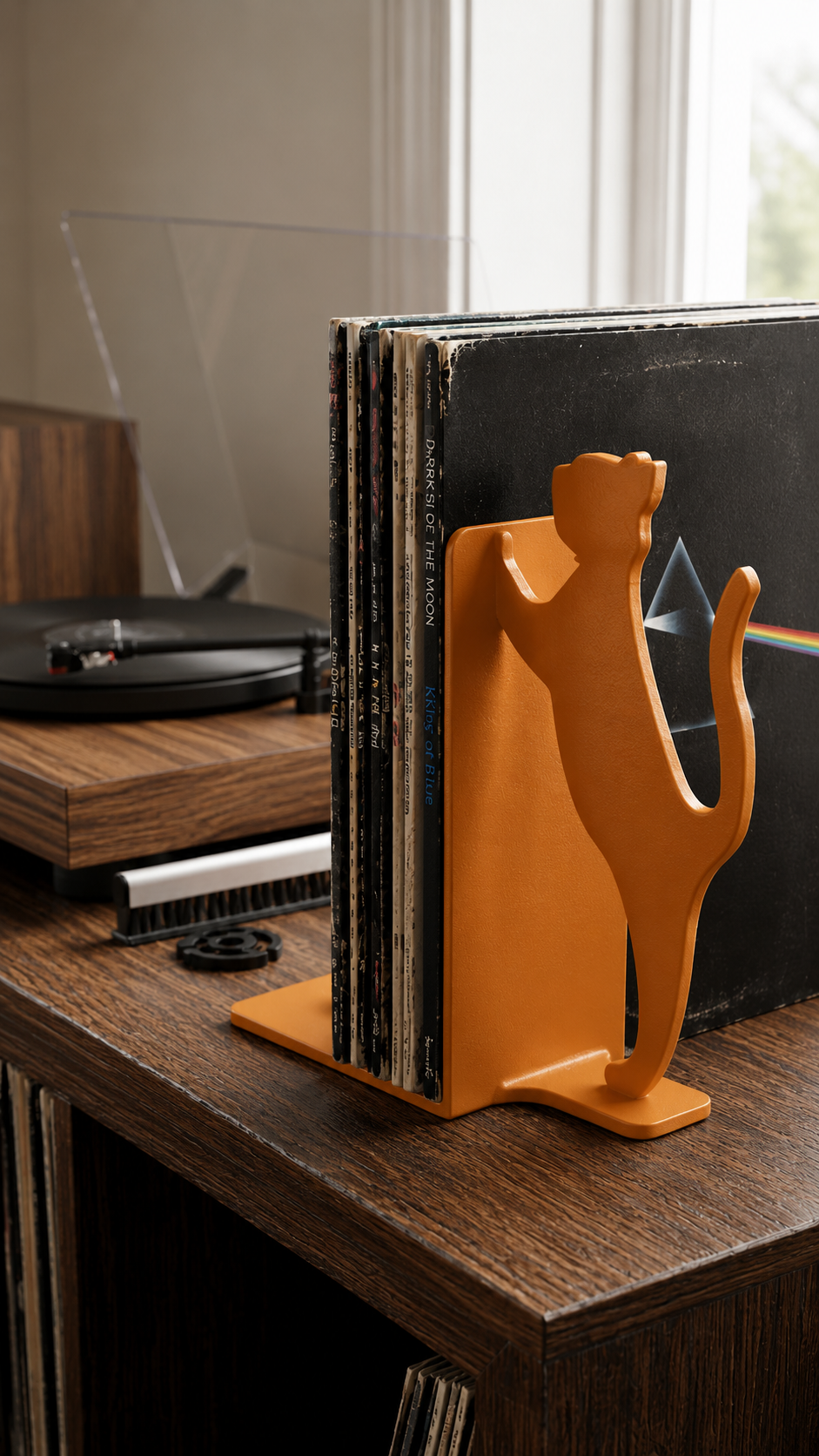 Orange cat silhouette vinyl record bookend in a living room setting.