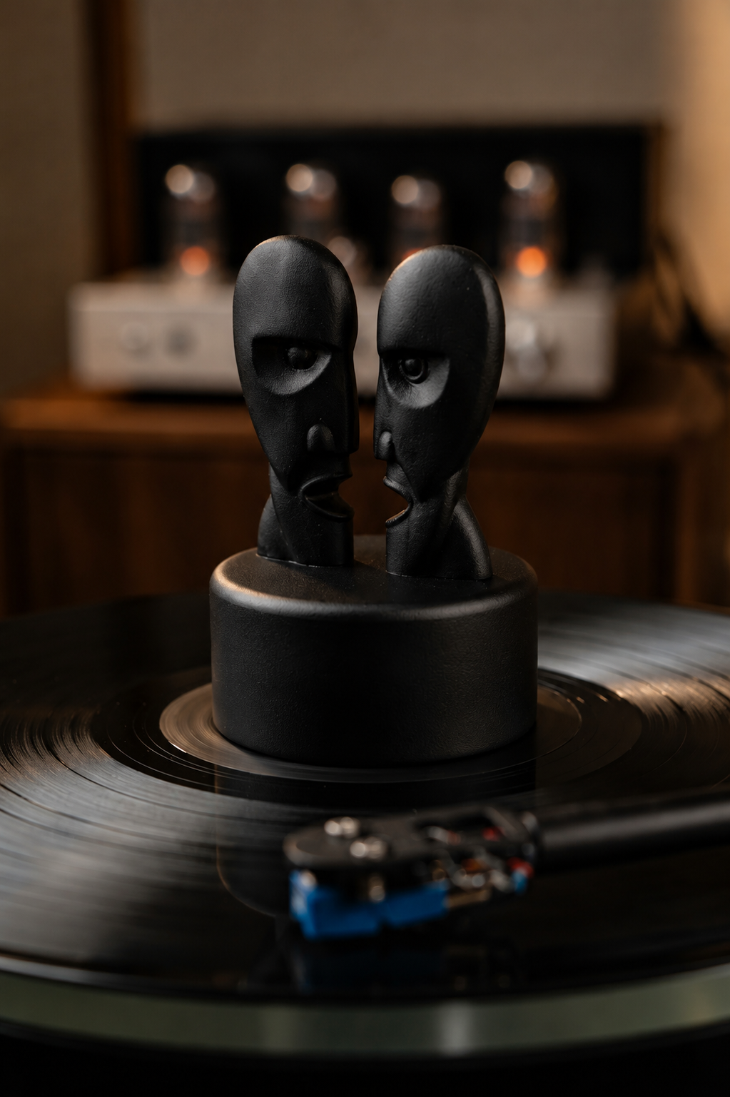 Black record stabilizer with dual face sculpture on a vinyl record.