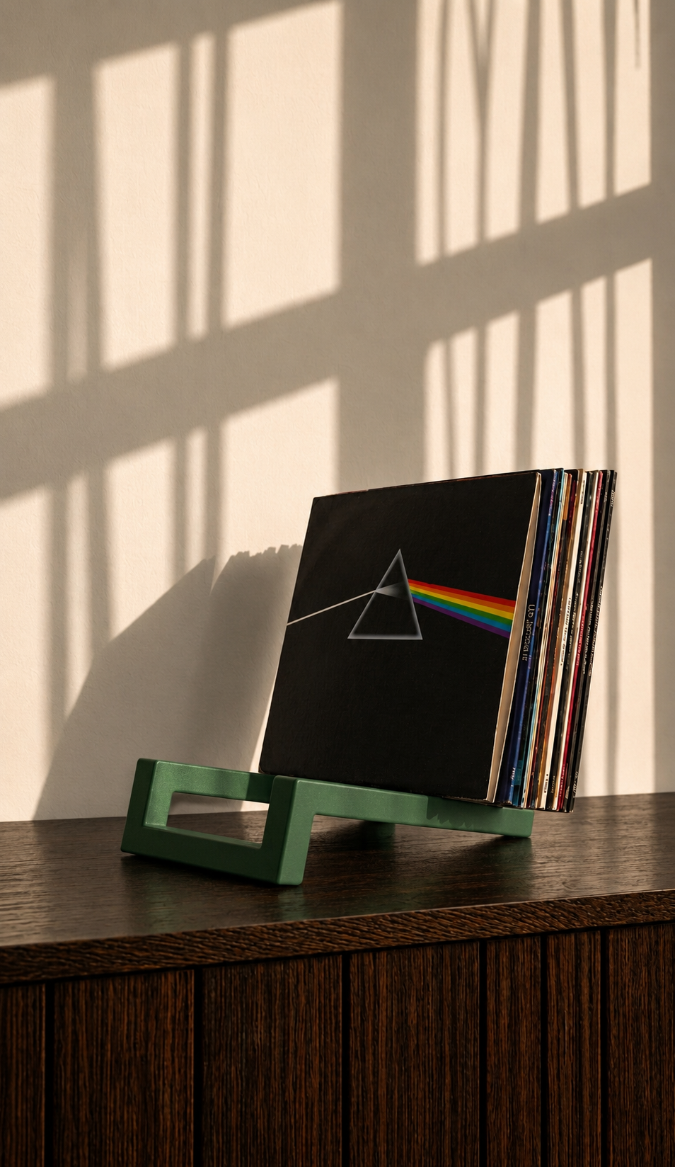 Green geometric vinyl record holder displaying a collection of albums.
