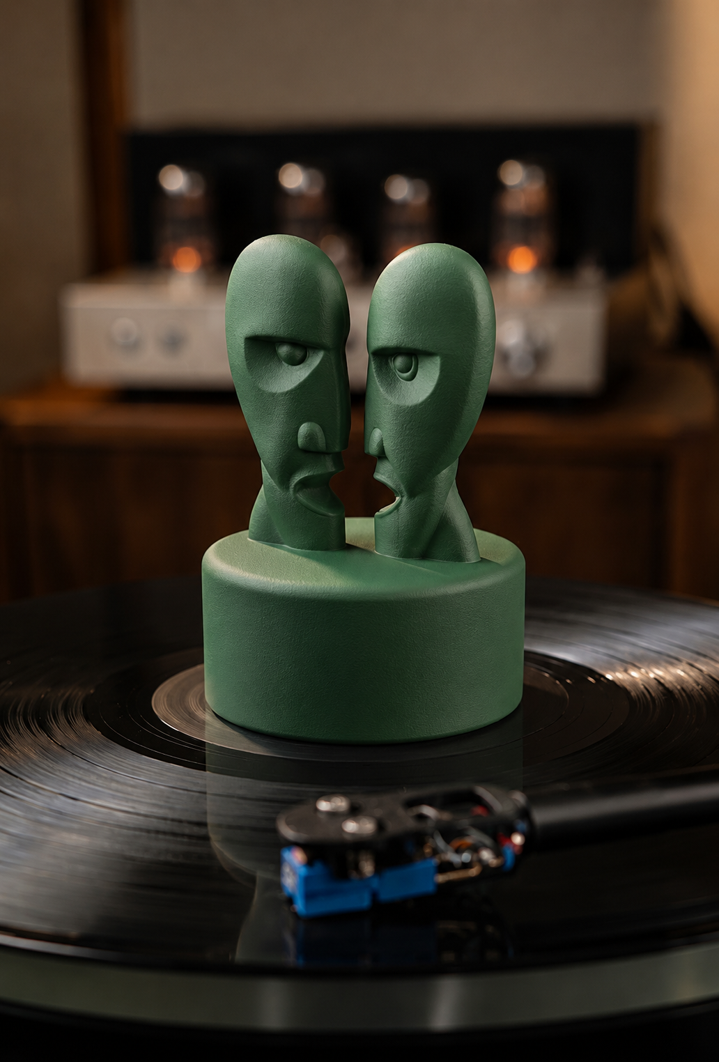 Green record stabilizer with dual face sculpture on a vinyl record.